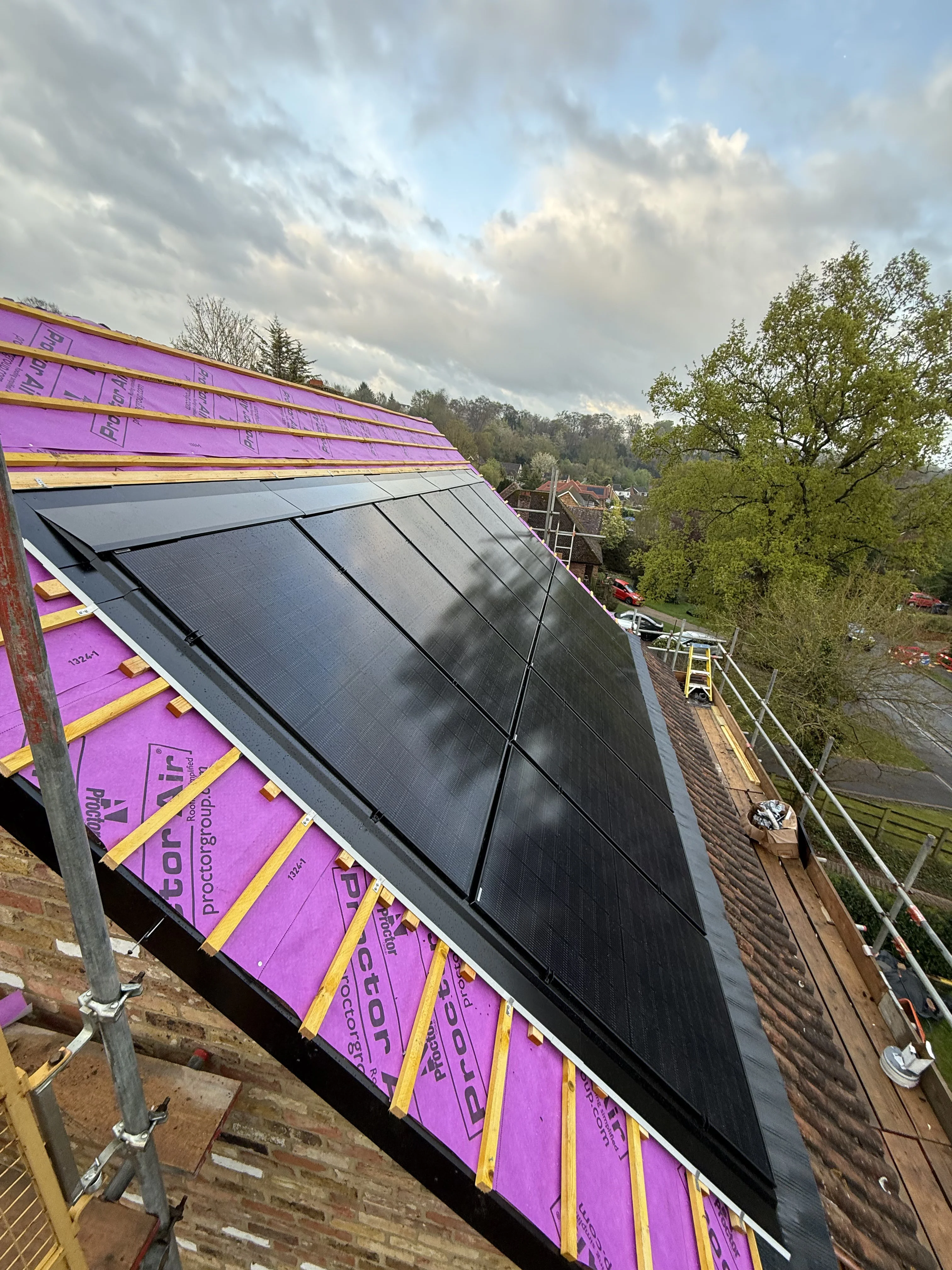 Solar panels being fitted to a roof, with the battens and membrane visible